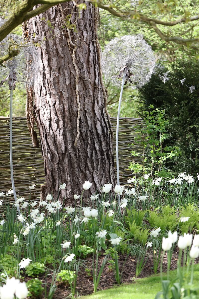 dandelion metal sculptures in an all white woodland