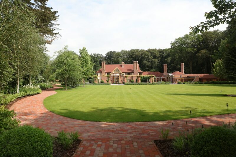 arts & Crafts mansion in red brick surrounded by landscaped garden in oxfordshire