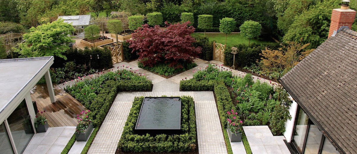 Outdoor living patio with water feature, box topiary hedging and tulip mix