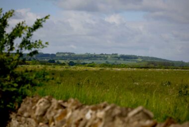 landscape view of Evenlode valley spring day hills sky and distant houses