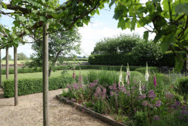 Kingham country cottage garden with trees flowers and lawn