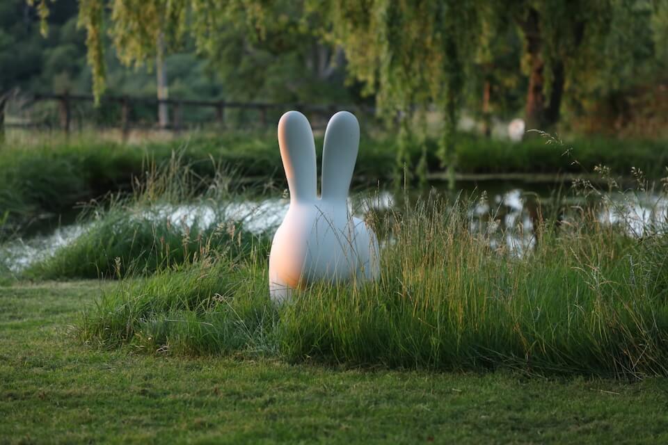 a white rabbit garden sculpture next to a lake in oxfordshire