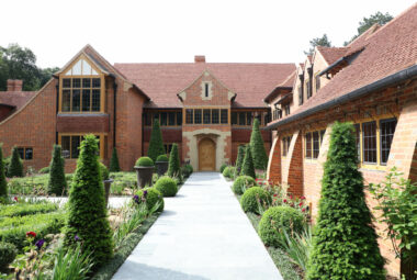 Harpsden Wood House in Henley-on-Thames with green grounds and gardens designed by Hendy Curzon Gardens