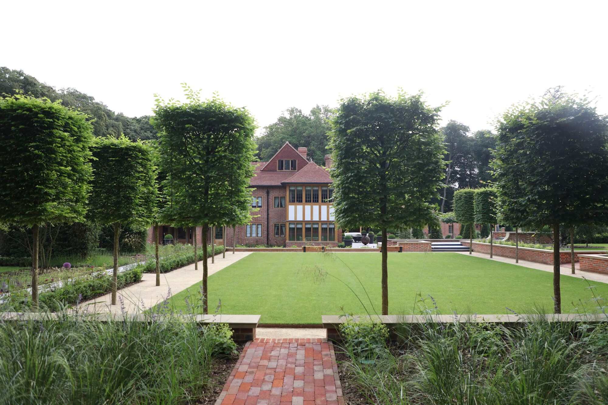 Harpsden Wood House in Henley-on-Thames with green grounds and gardens designed by Hendy Curzon Gardens