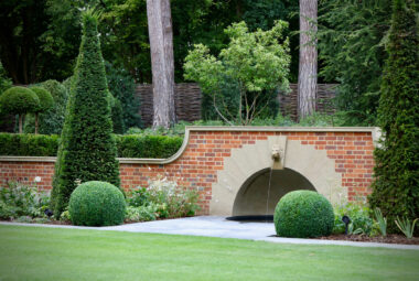 Grand garden topiary and a lion water fountain in an English Garden