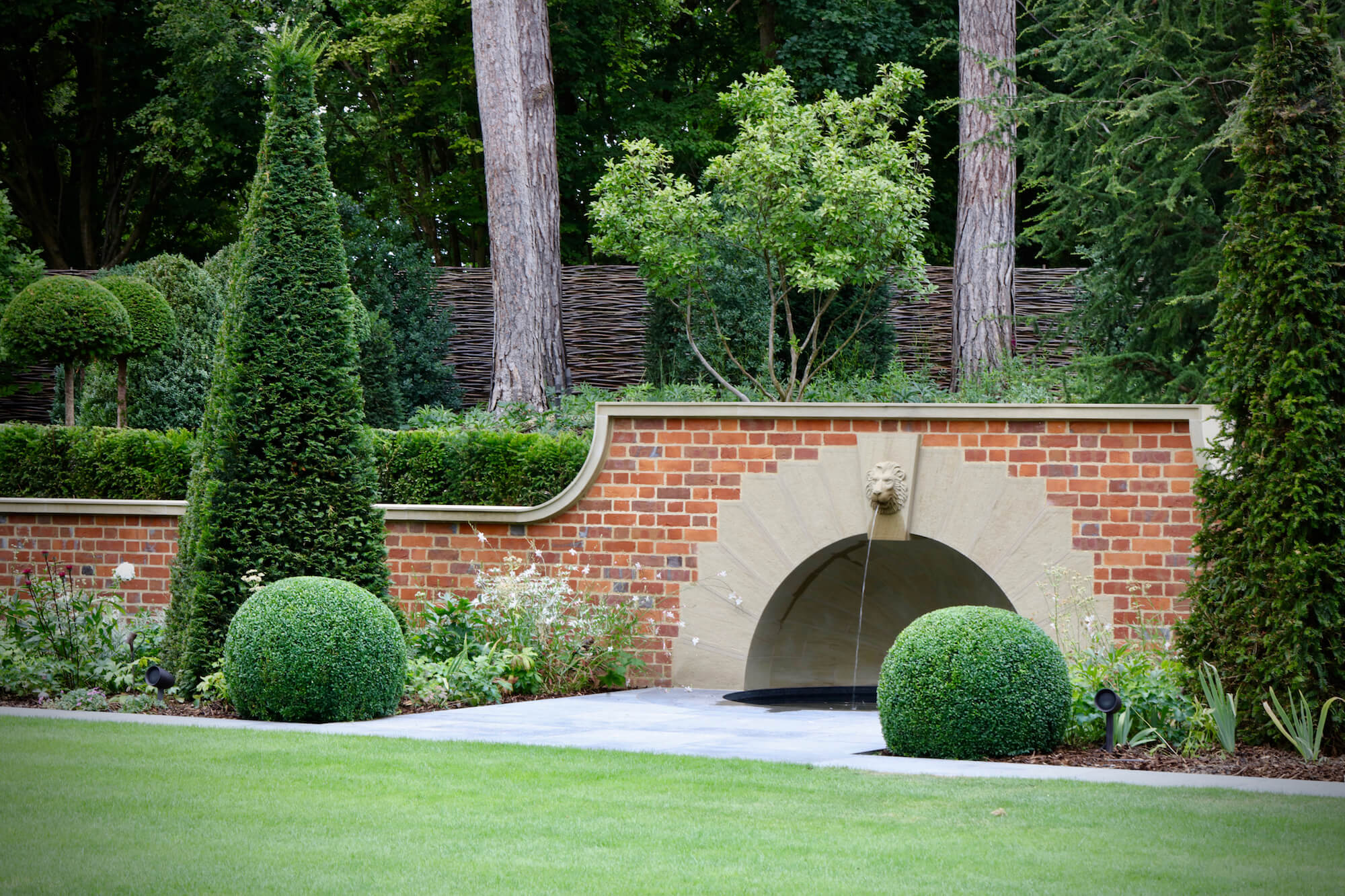 Grand garden topiary and a lion water fountain in an English Garden