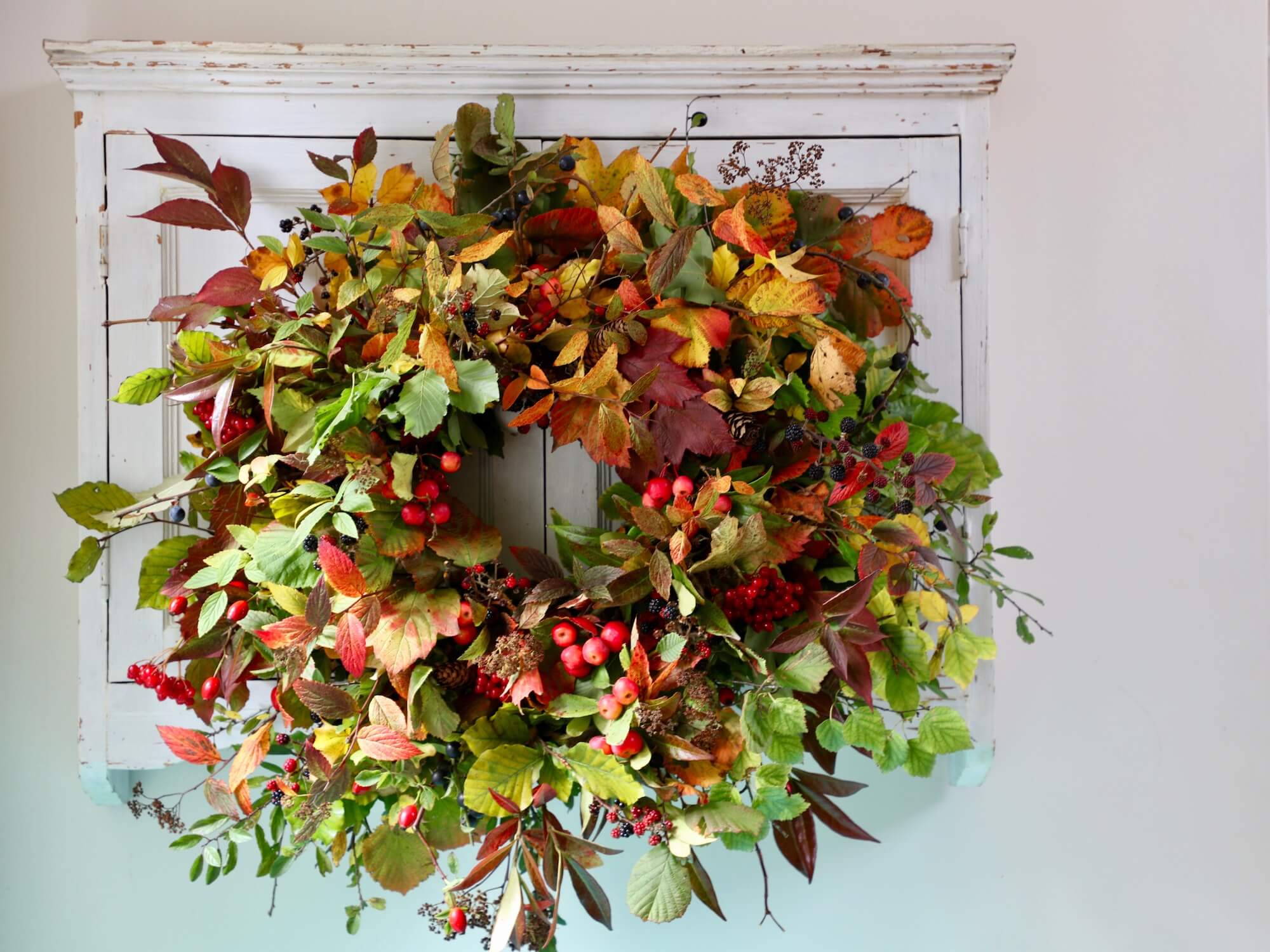 an autumn wreath made up of leaves and berries from a September garden