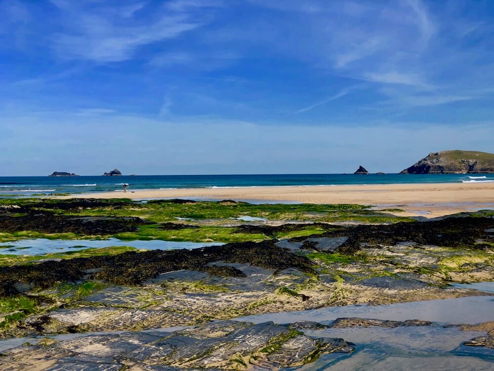 Constantine bay seascape in summer blue sea green seaweed and black rocks yellow sand