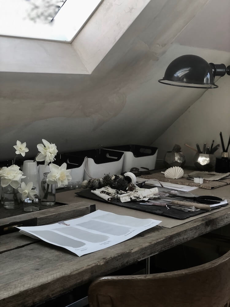 garden design studio loft with black lamp and desk full of paint swatches and garden flowers