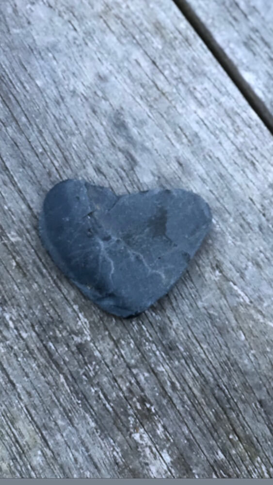 a slate stone shaped like a heart on driftwood