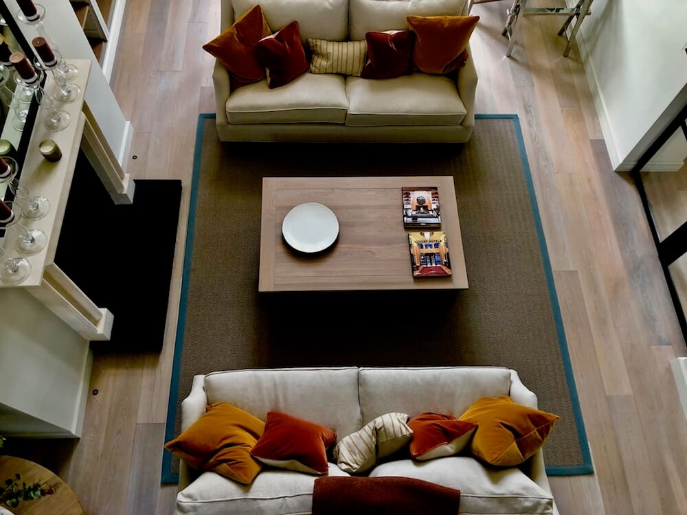 an interred designed home with white couches and orange cushions