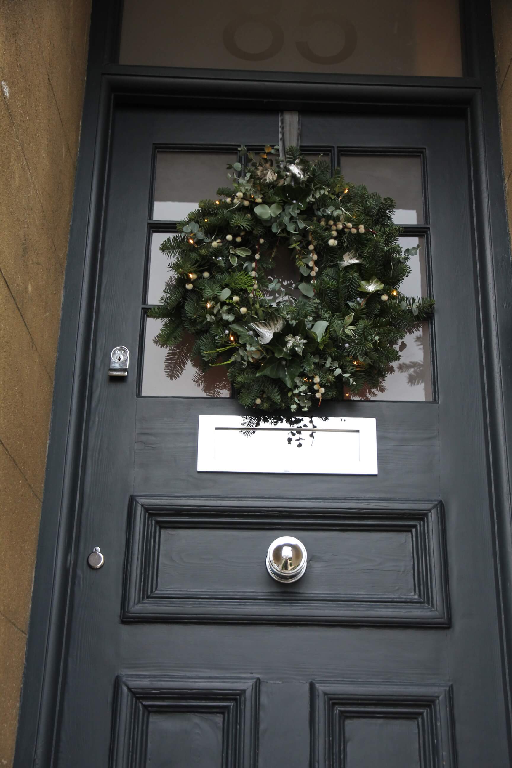 front door of Edwardian townhouse painted dark blue with wreath