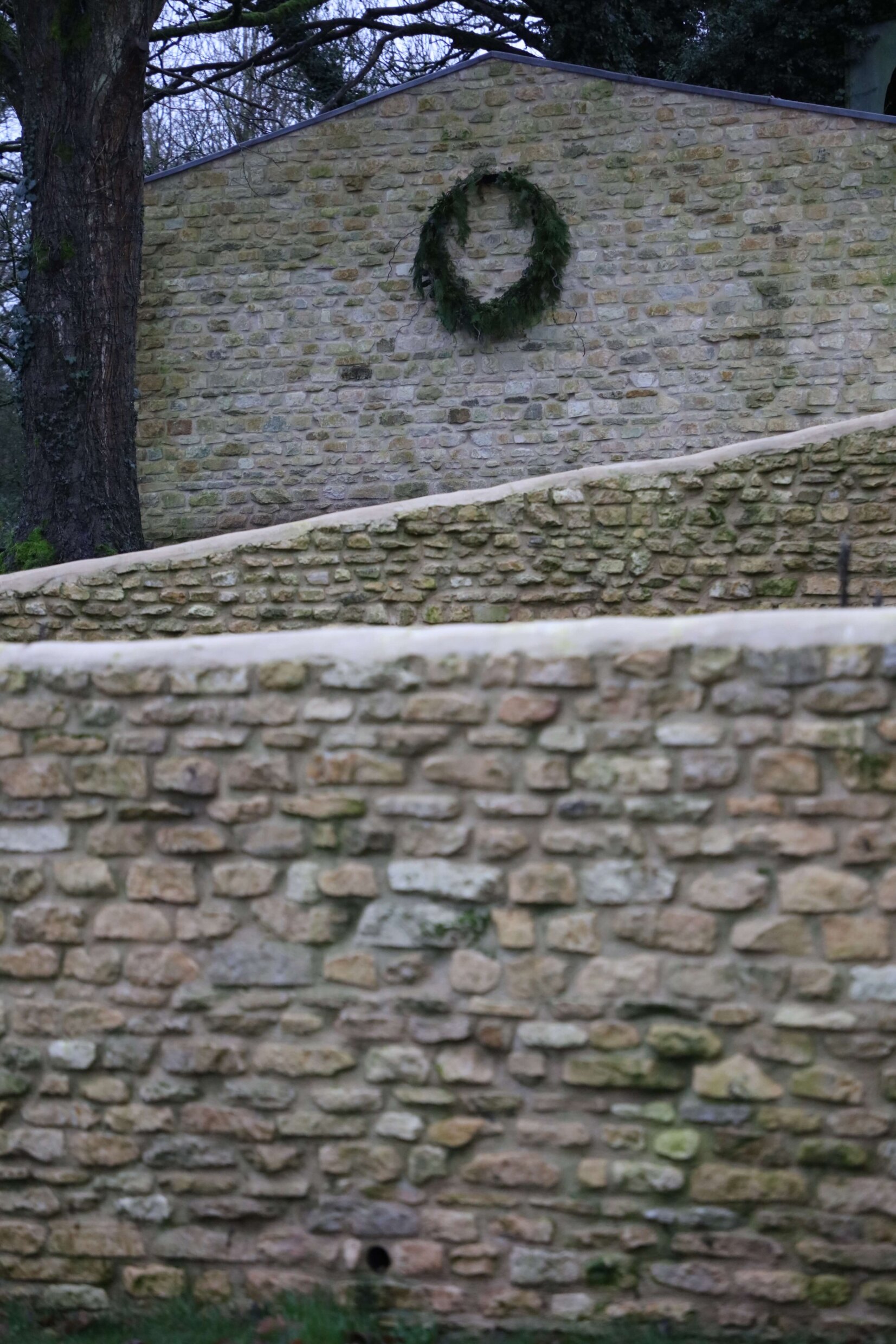 giant barn wreath hanging on stone barn