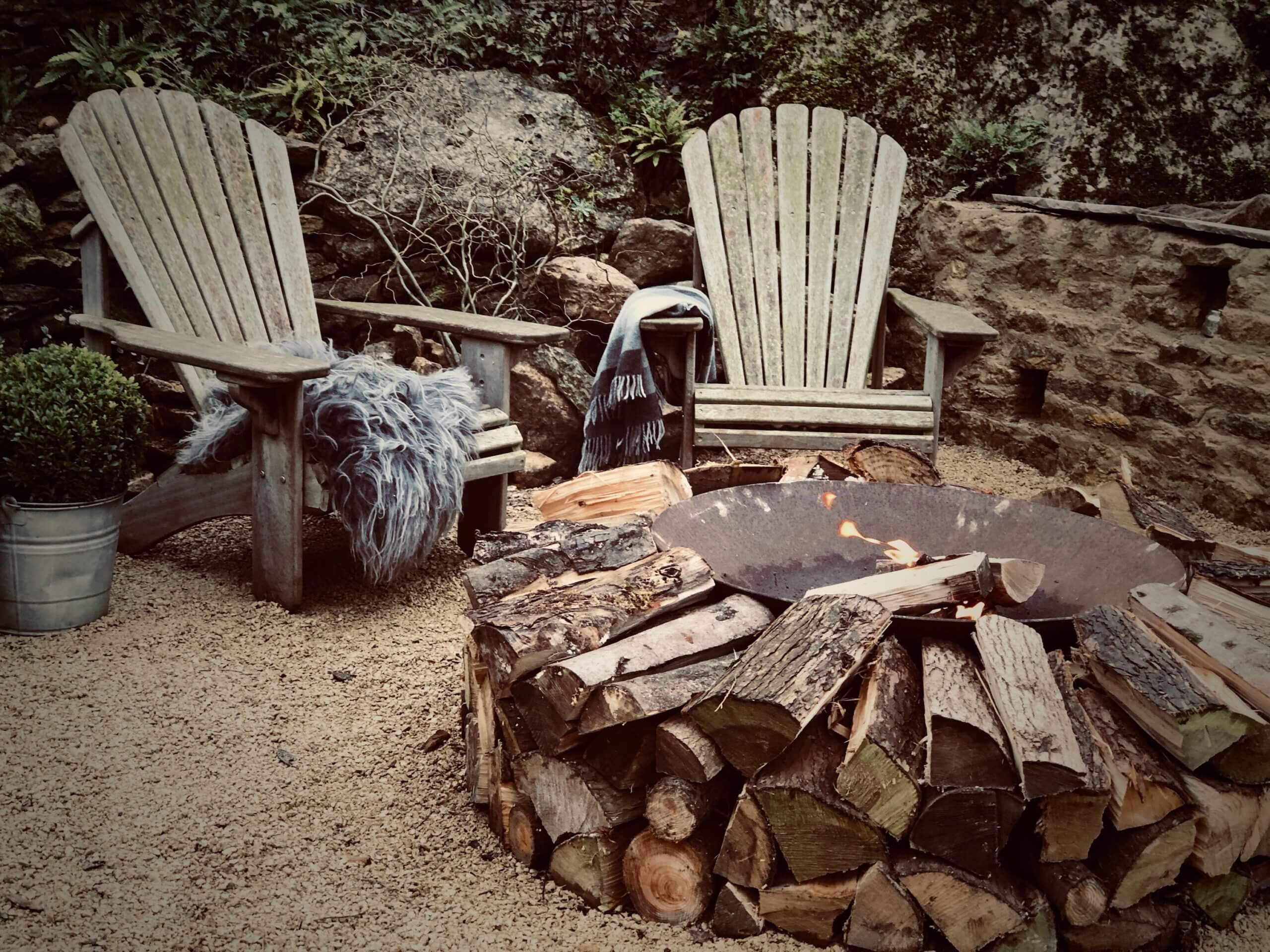 winter hygge garden with fire pit and Adirondack chairs