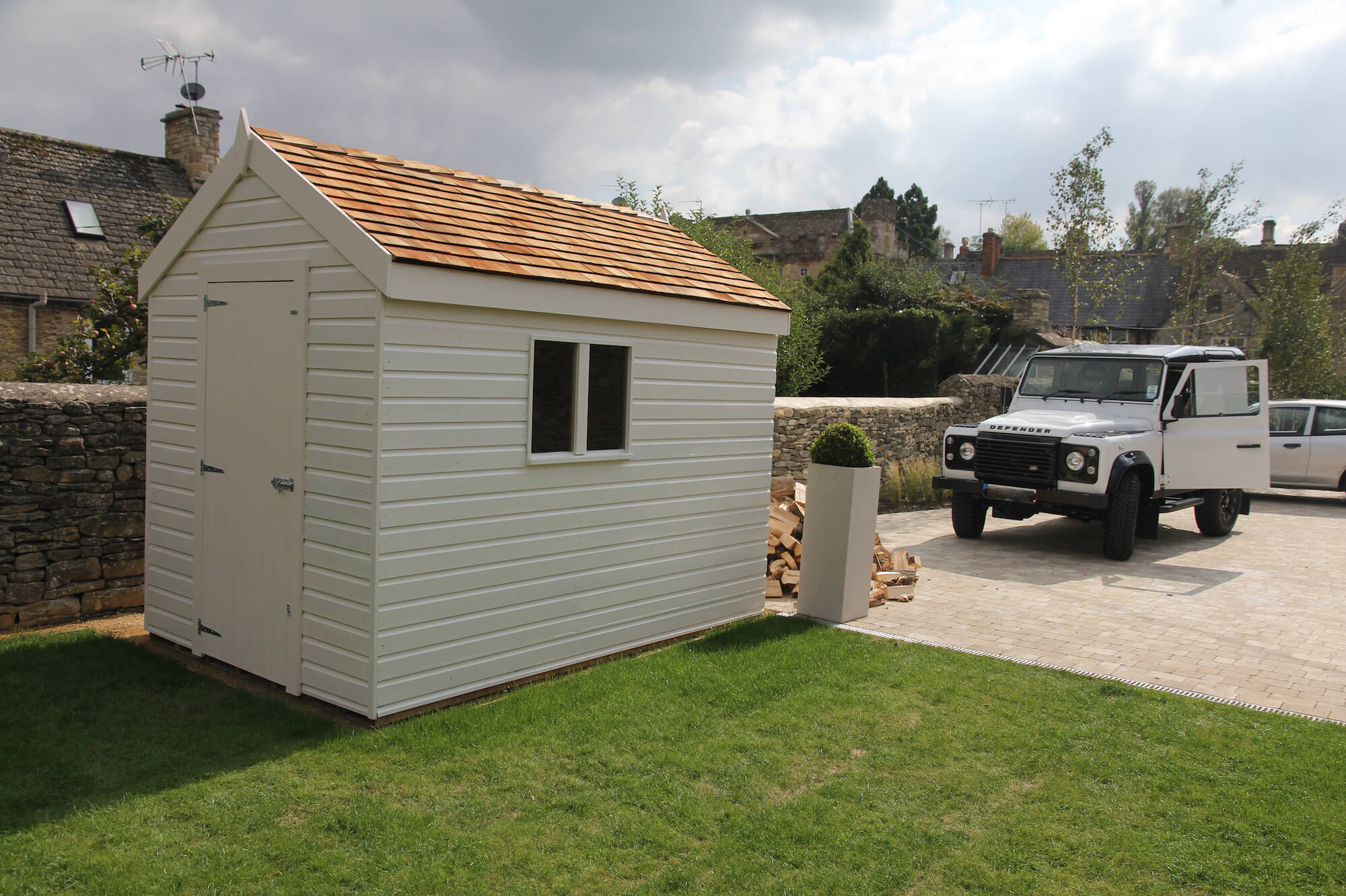 Land Rover Defender black and white in a Burford Garden under construction