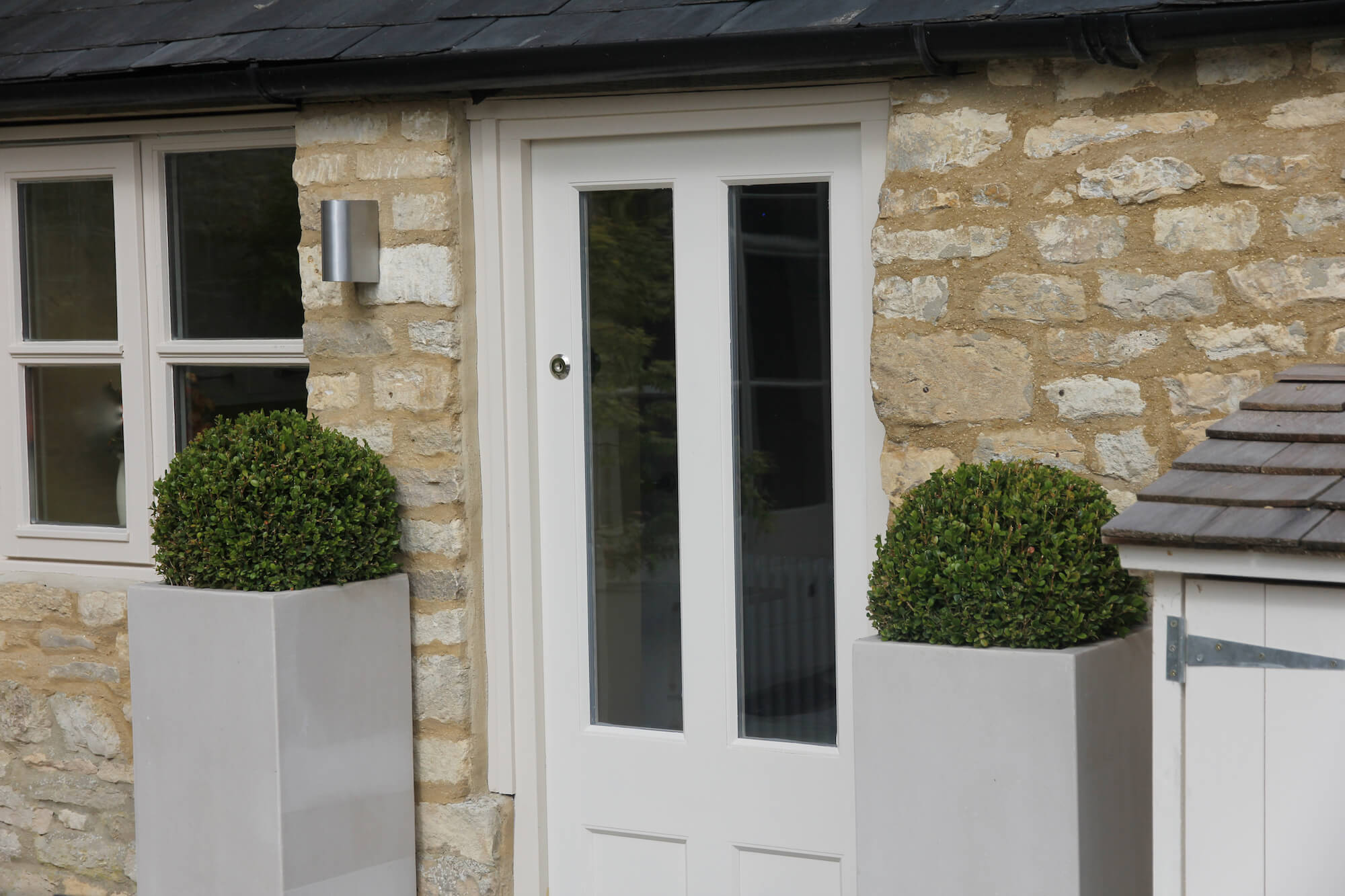 Burford the bield garden front door and tall planters with Buxus balls