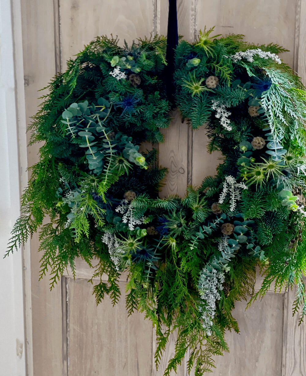 Relaxed soft christmas wreath against wooden door
