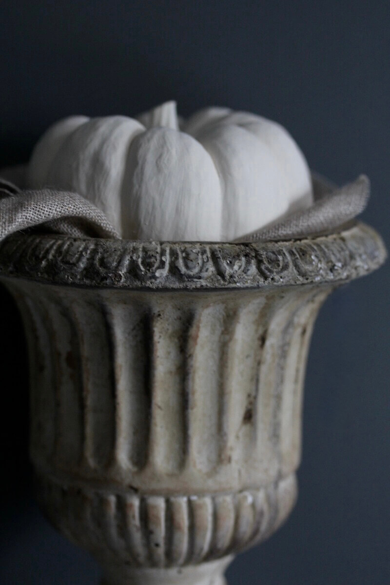White gourd inside small stone urn