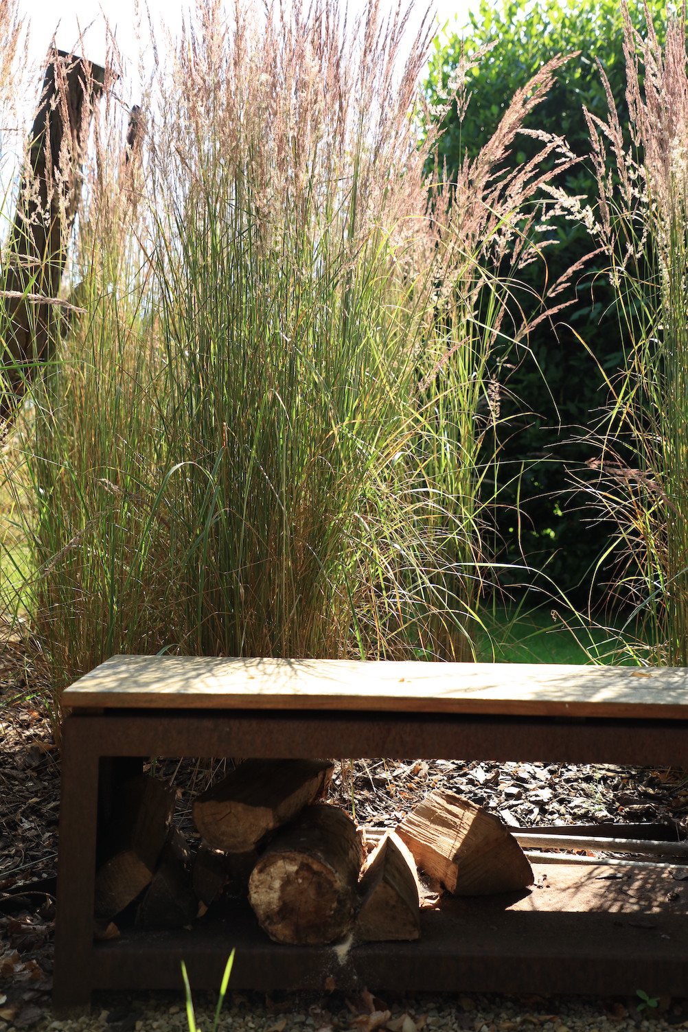 Log store bench in front of soft grass