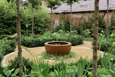 Side view of parterre garden showing border packed full of lush green plants