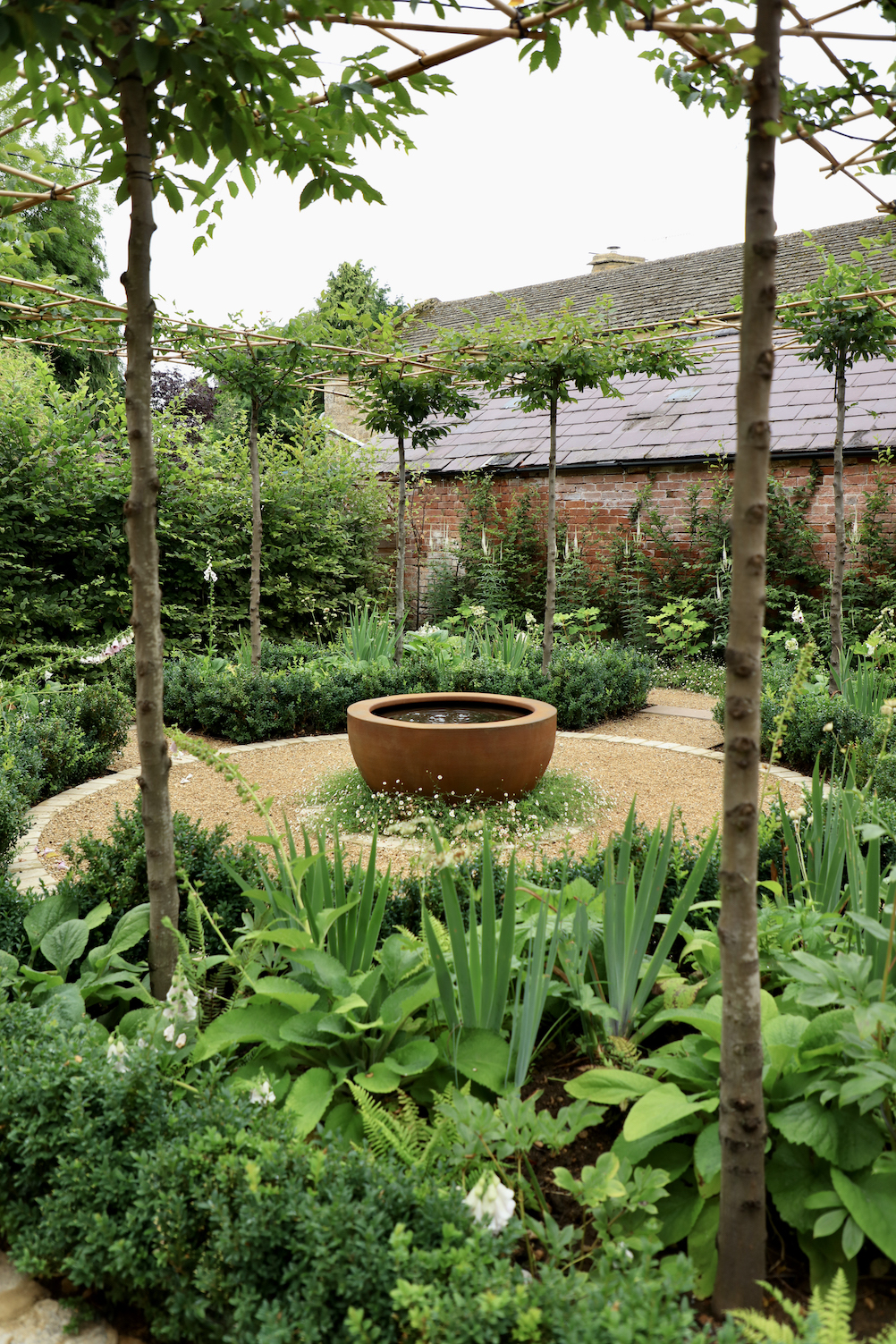 Side view of parterre garden showing border packed full of lush green plants