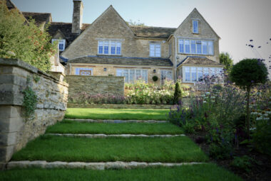 Lush green lawn at the back of stone property