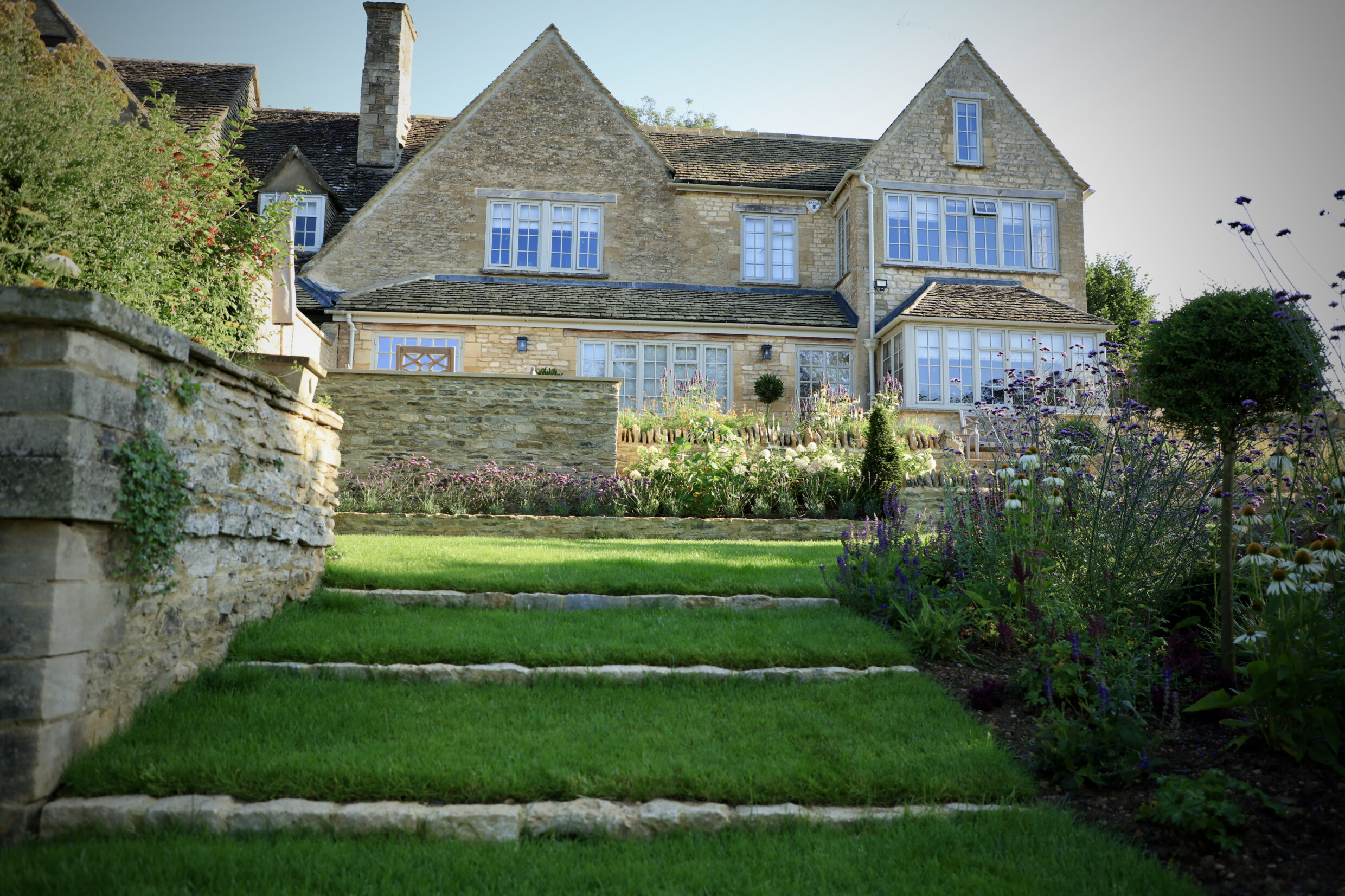 Lush green lawn at the back of stone property