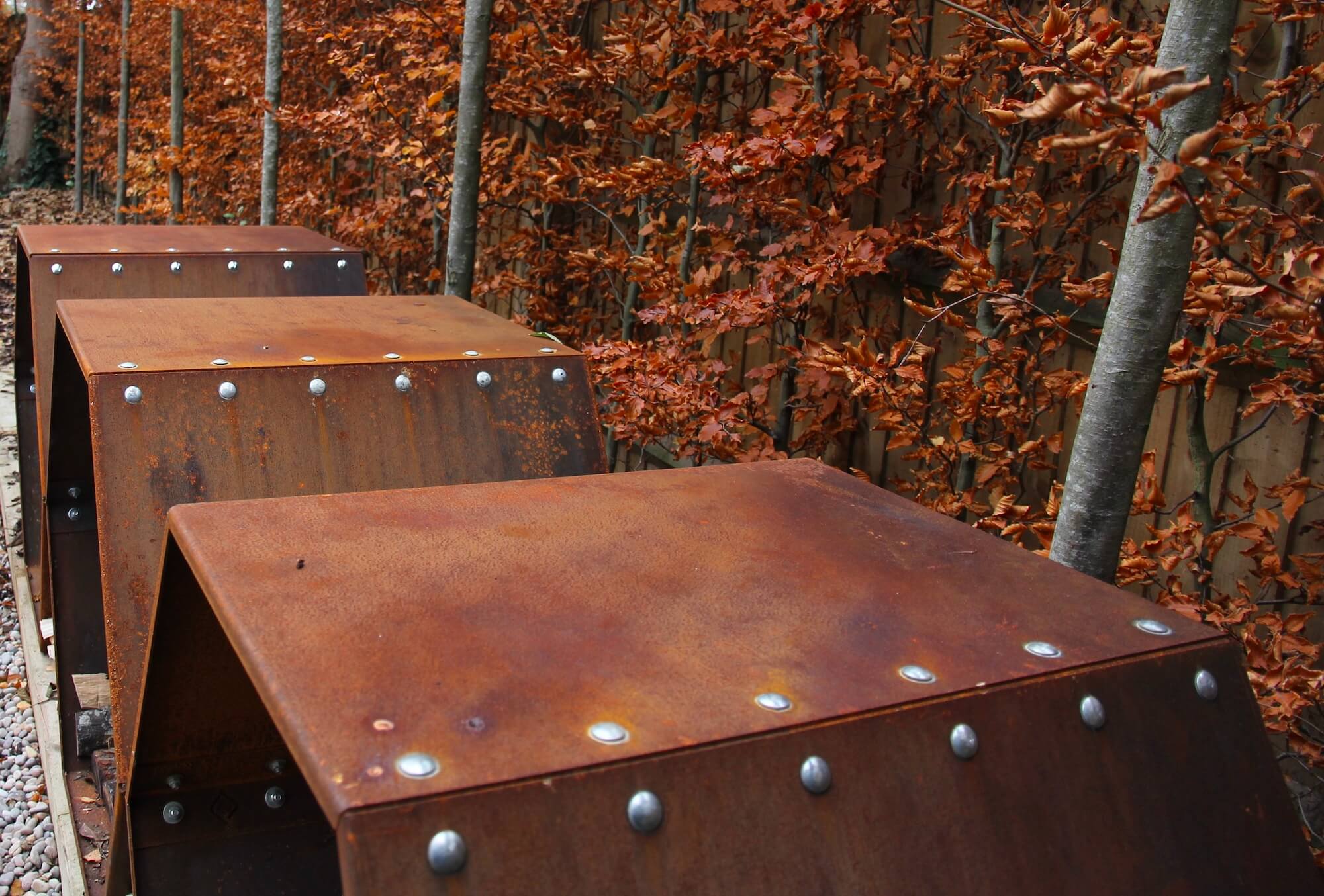 corten beehive log stores in autumn