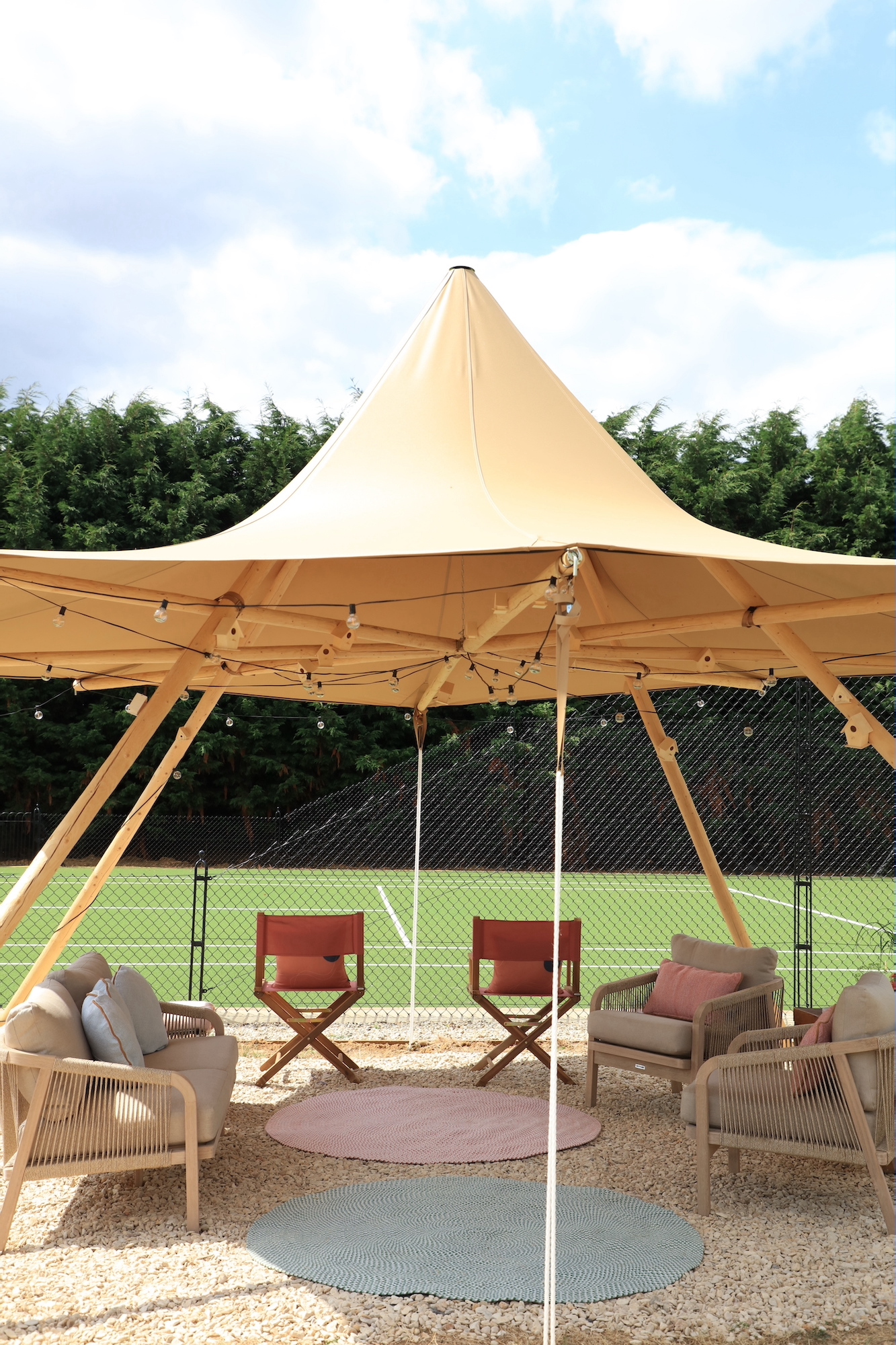 Rough luxe yurt with kettler furniture and festoon lights