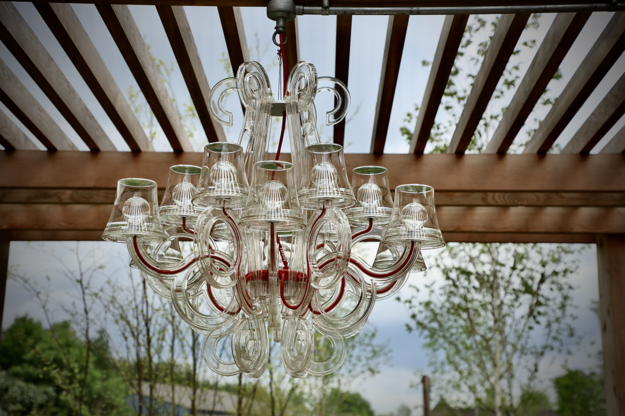 Fatboy chandelier hanging from garden arbor in Cotswold garden 