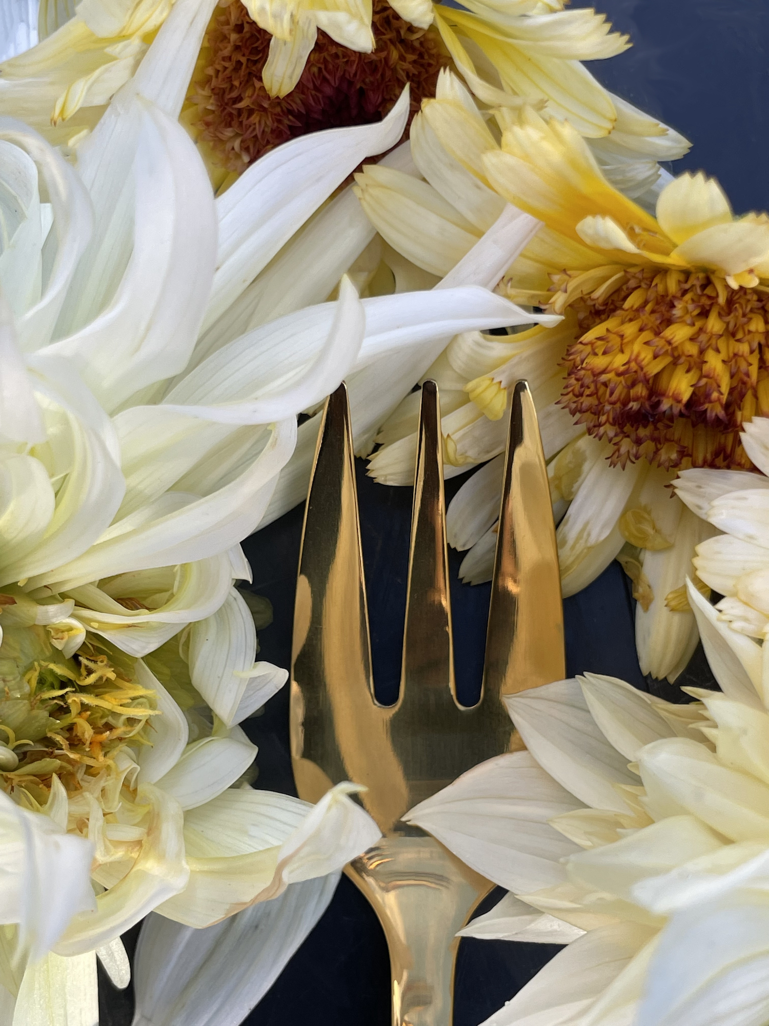Close up of edible dahlias and gold cake fork