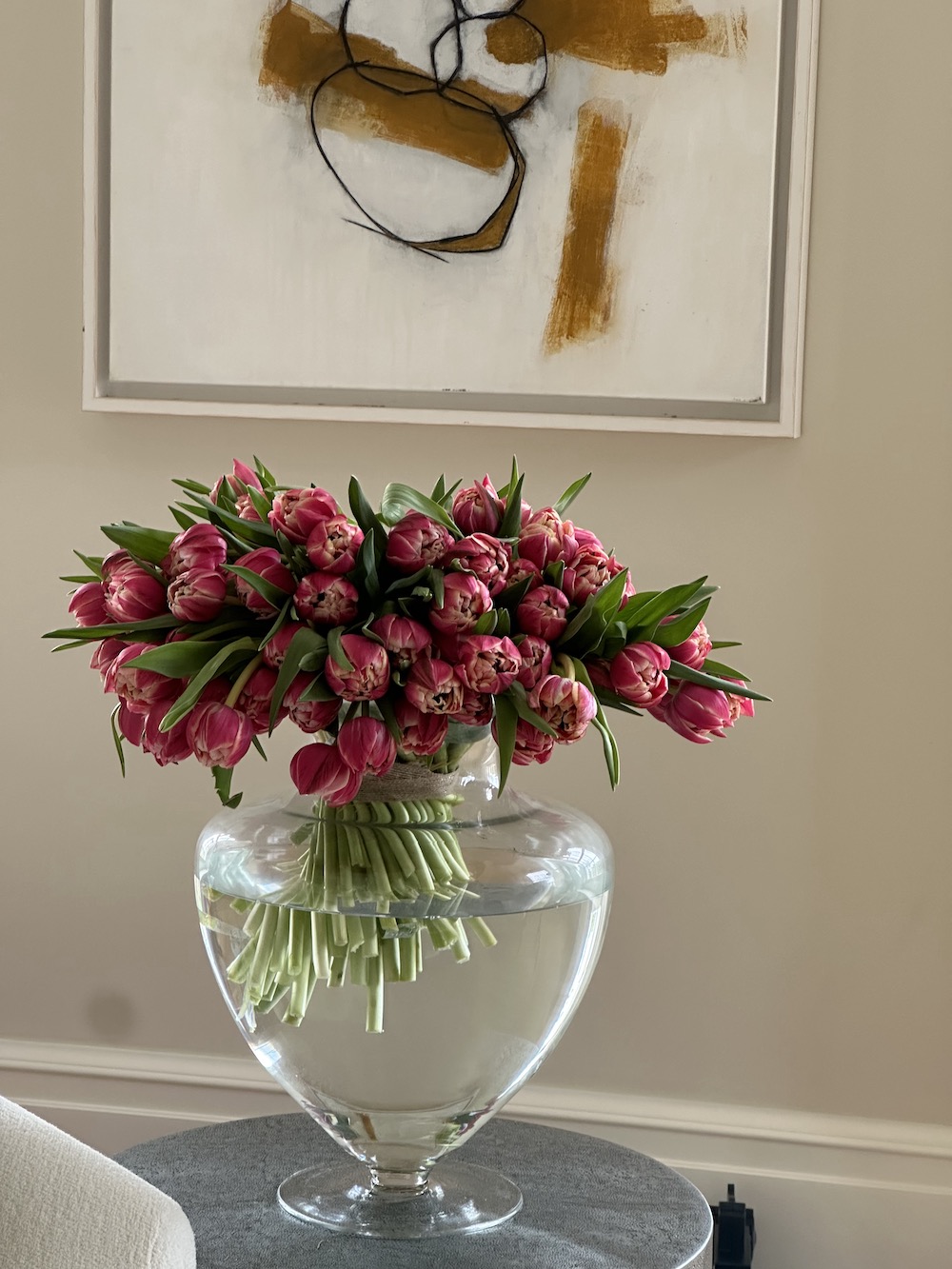 Floral installation at Sibford Park of hot pink tulips In hurricane glass vase