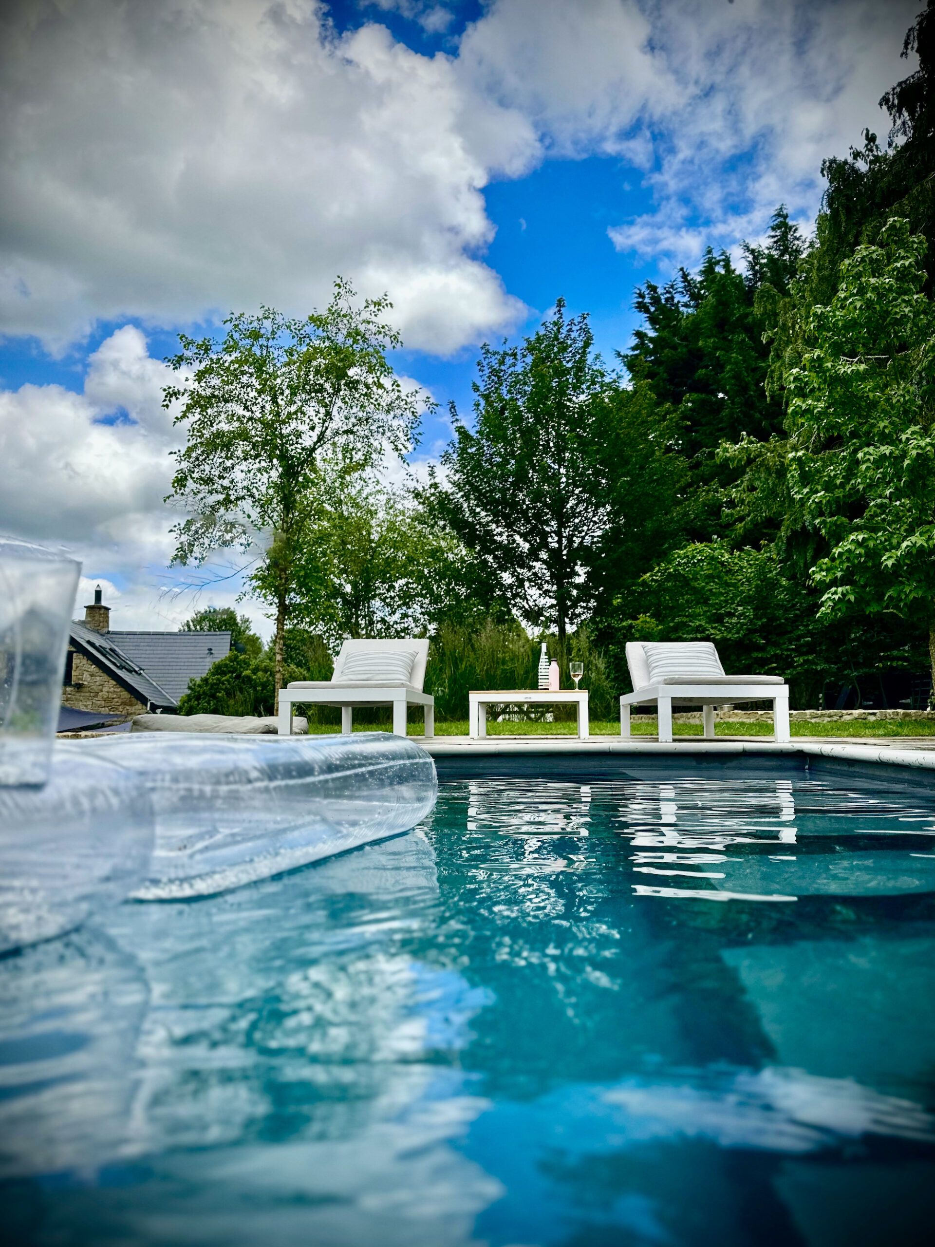 Cotswold swimming pool with Kettler sun loungers on sunny afternoon with pool inflatables 