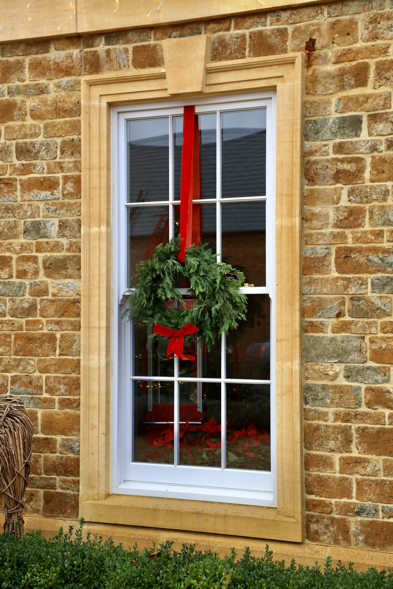 Georgian sach window with spruce wreath and velvet red ribbon
