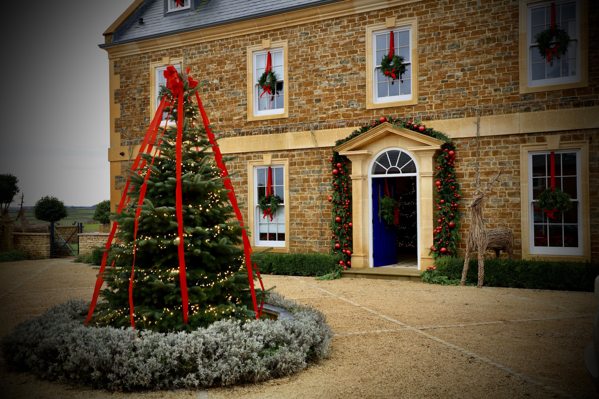Georgian manor house courtyard decorated for Christmas with velvet red bows