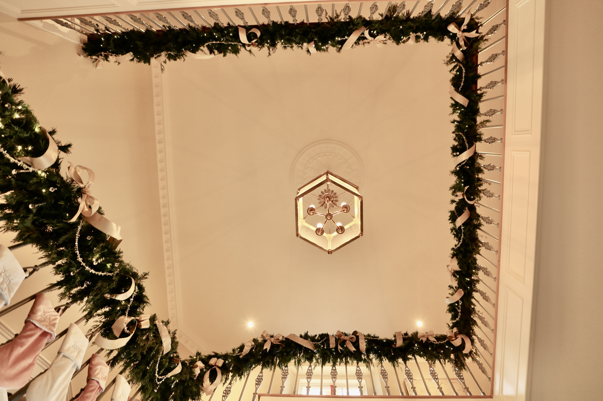 Christmas garland andstockings wraping around Georgian manor stair case