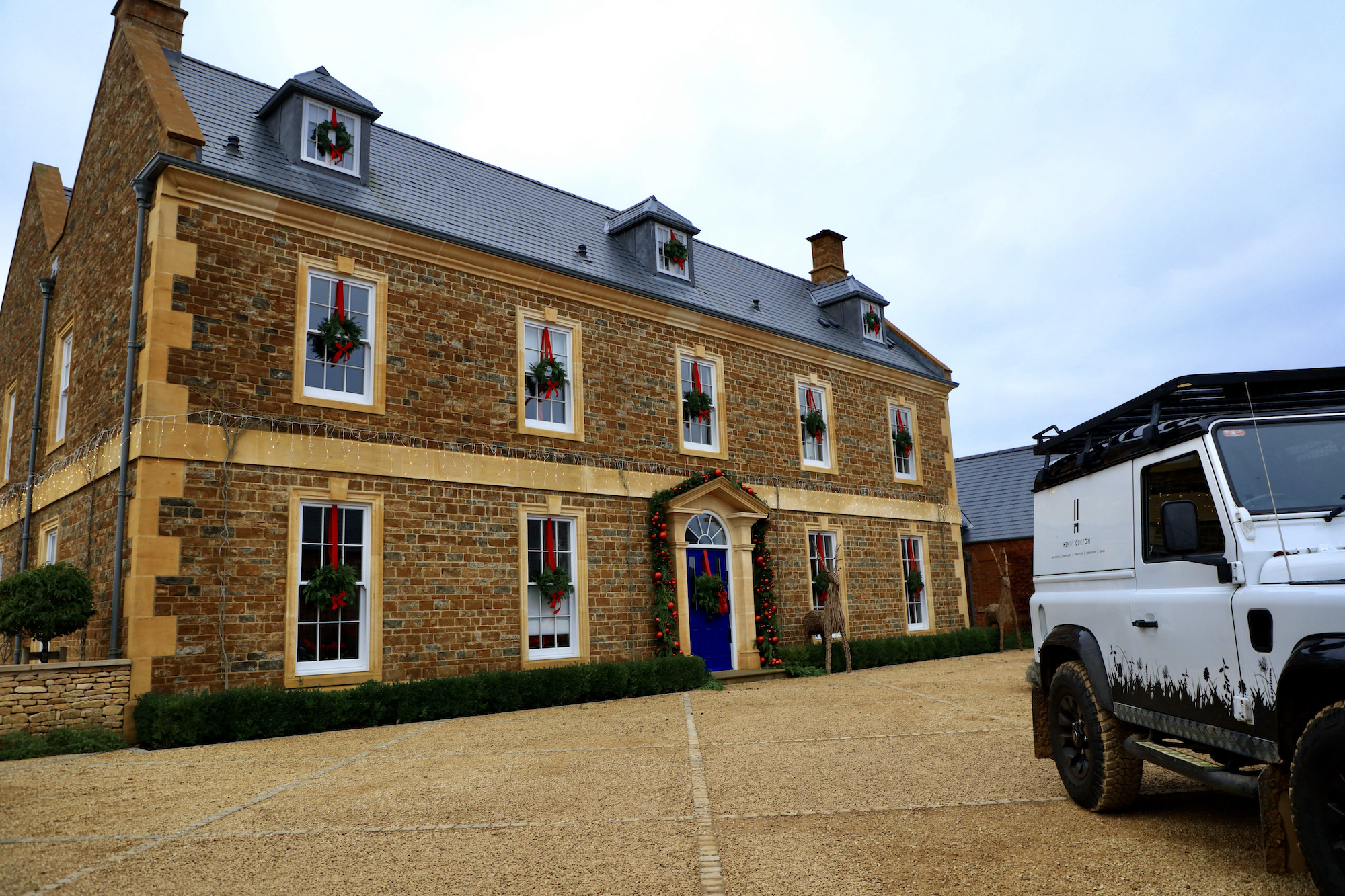 Georgina manor house decorated for Christmas with wreaths and White Landrover defender 