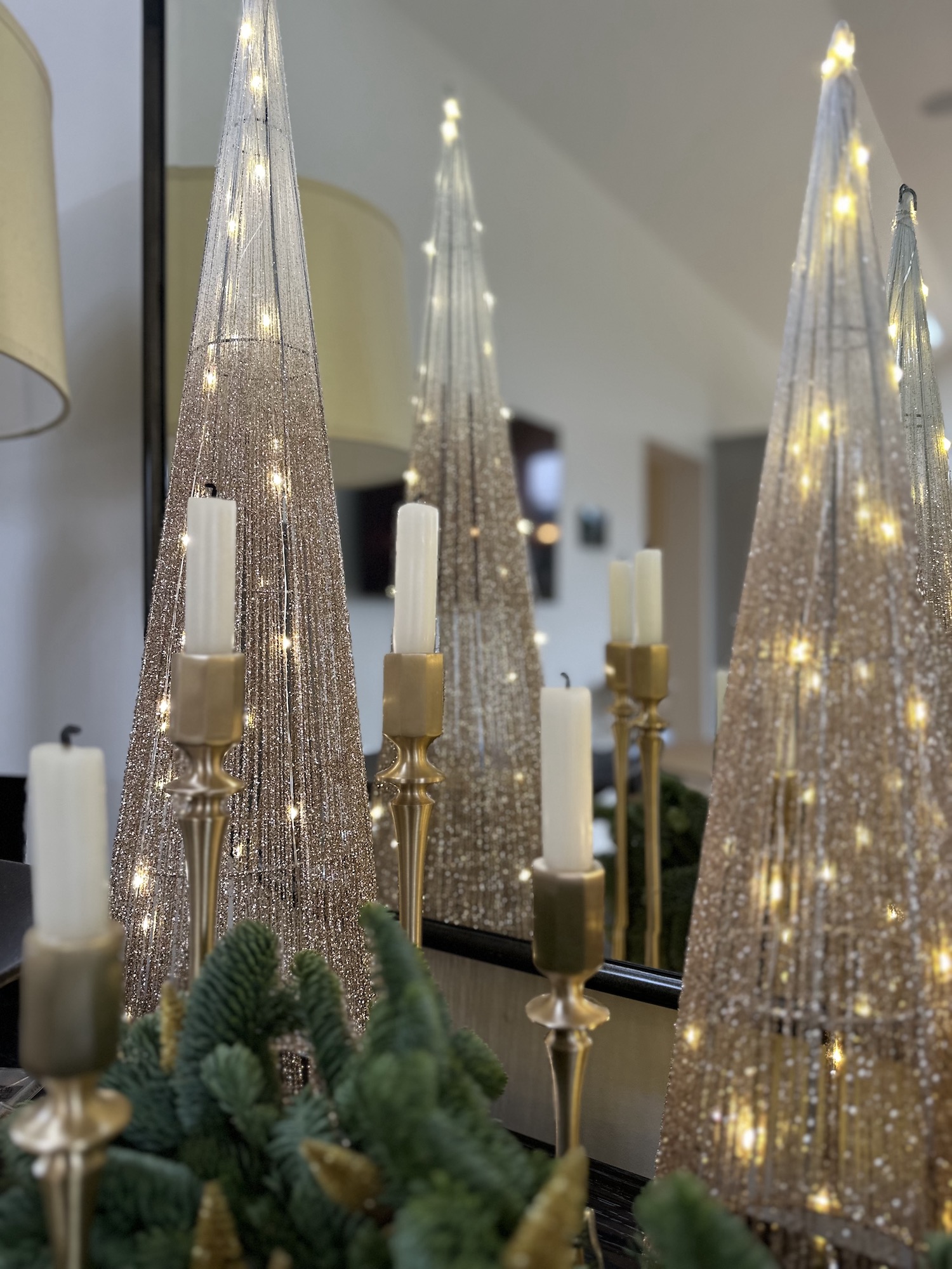 Gold cone fairy lit Christmas trees and gold candle holders in Cotswold home tablescape 