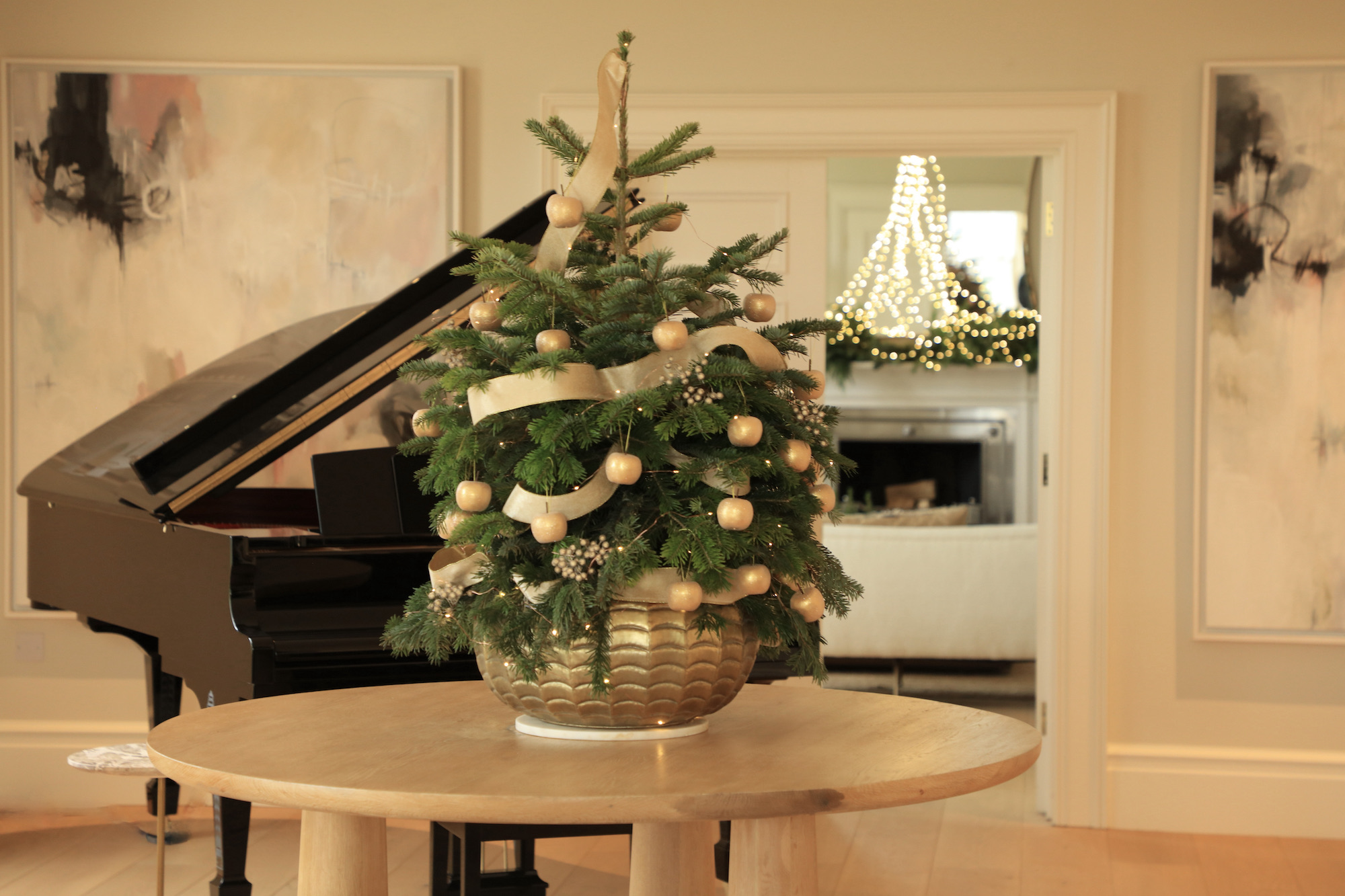 Mini potted christmas tree decorated with golden and velvet ribbon by grand steinway piano 