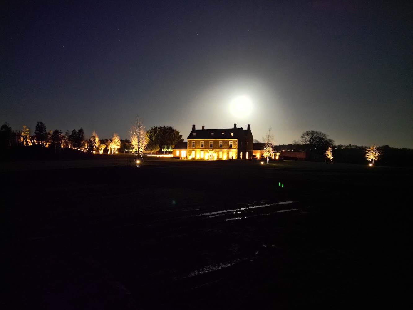 Moon in the night sky over Georgian Manor House 