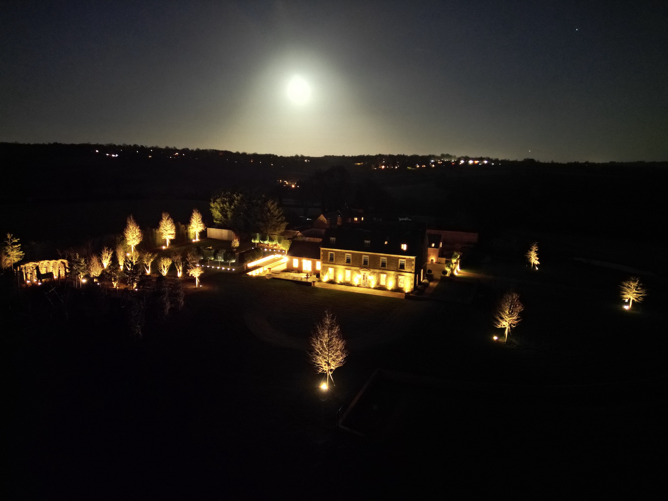 Drone footage of Sibford Park at night with lighting scheme