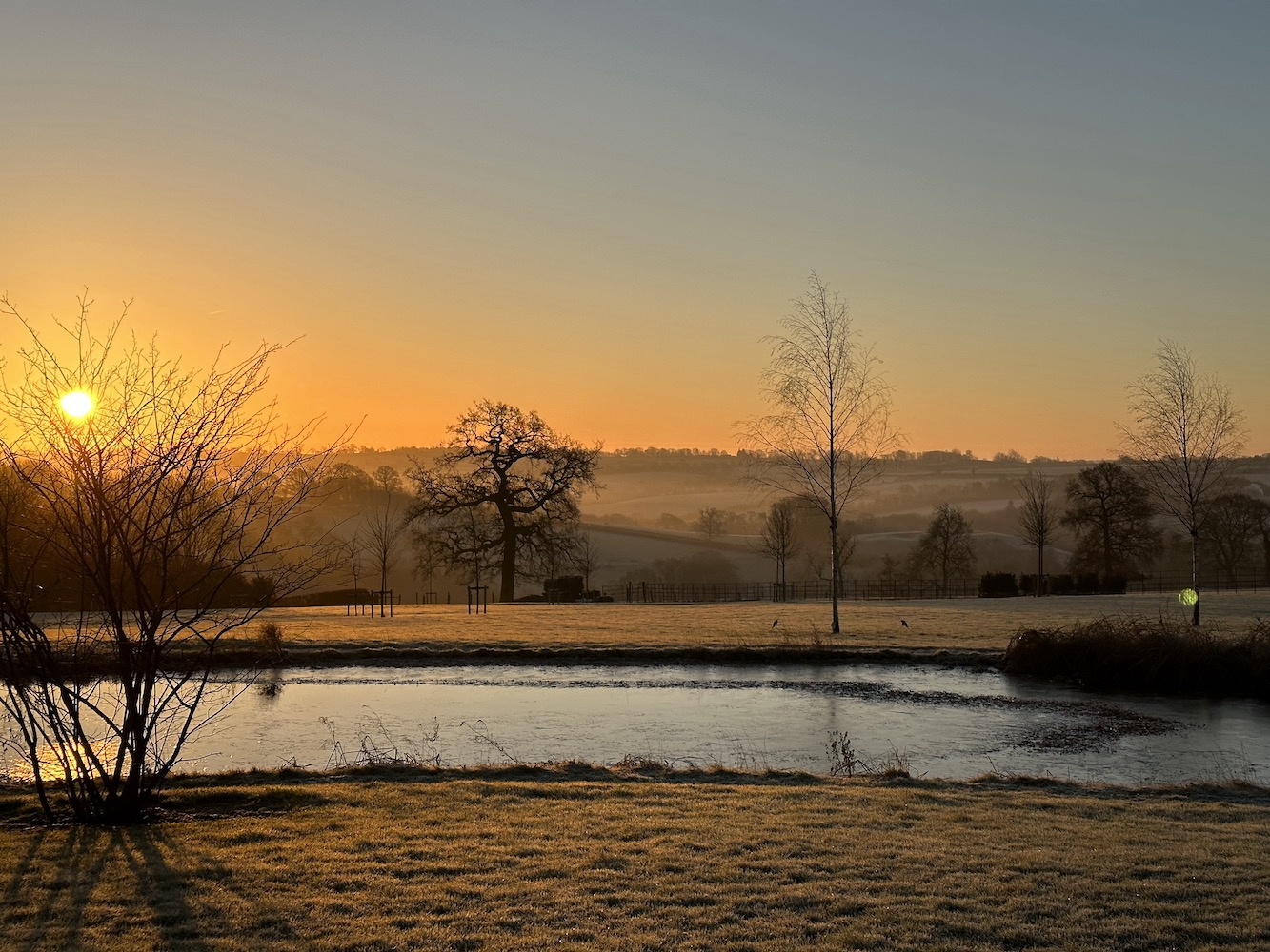 Sunset over Blenheim palace lake in Winter scene