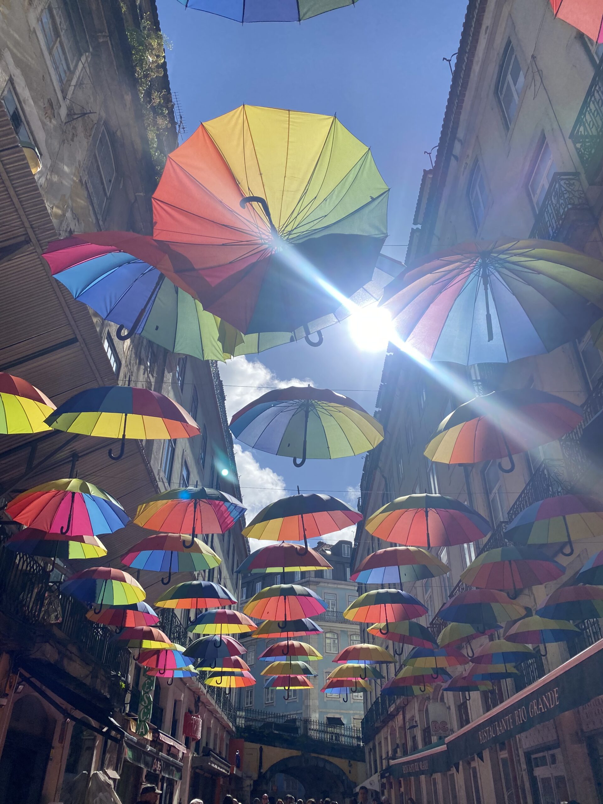 Pink street in Lisbon with colourful umbrellas 