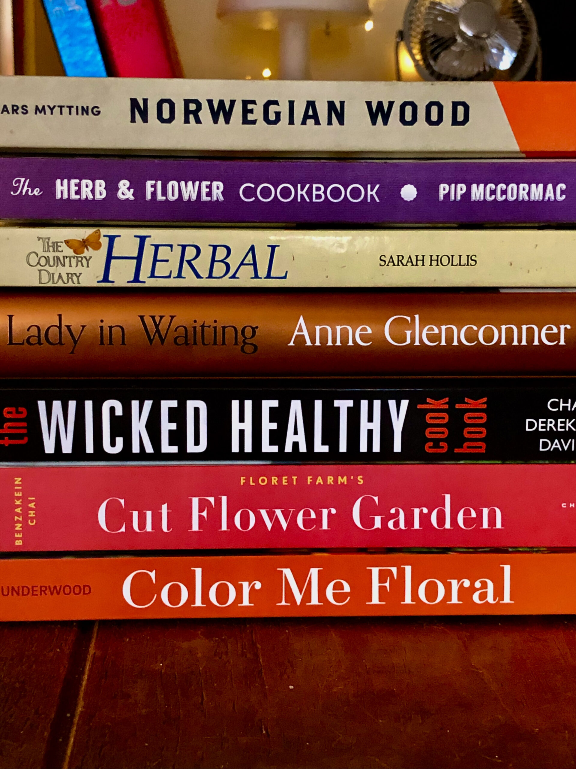 Selection of floral garden books and recipe books stacked in garden designers working studio